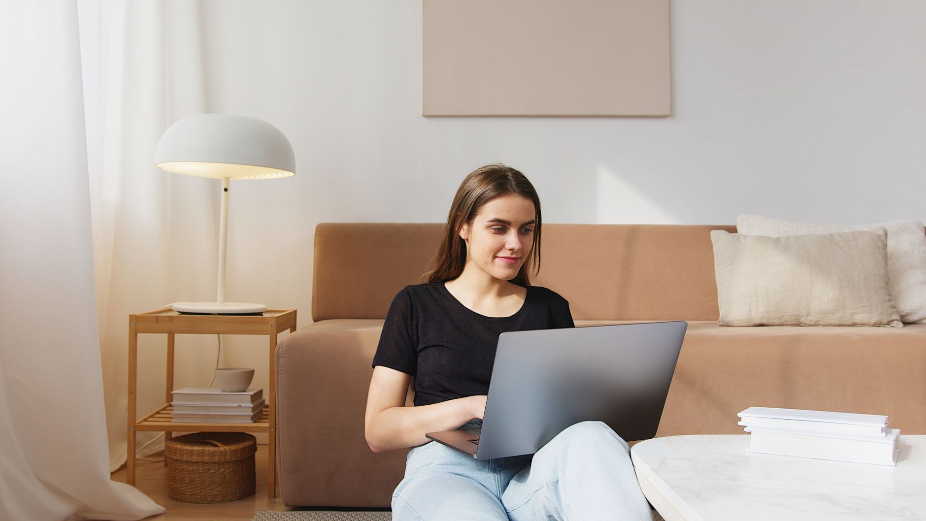 Woman using a laptop on a sofa at home